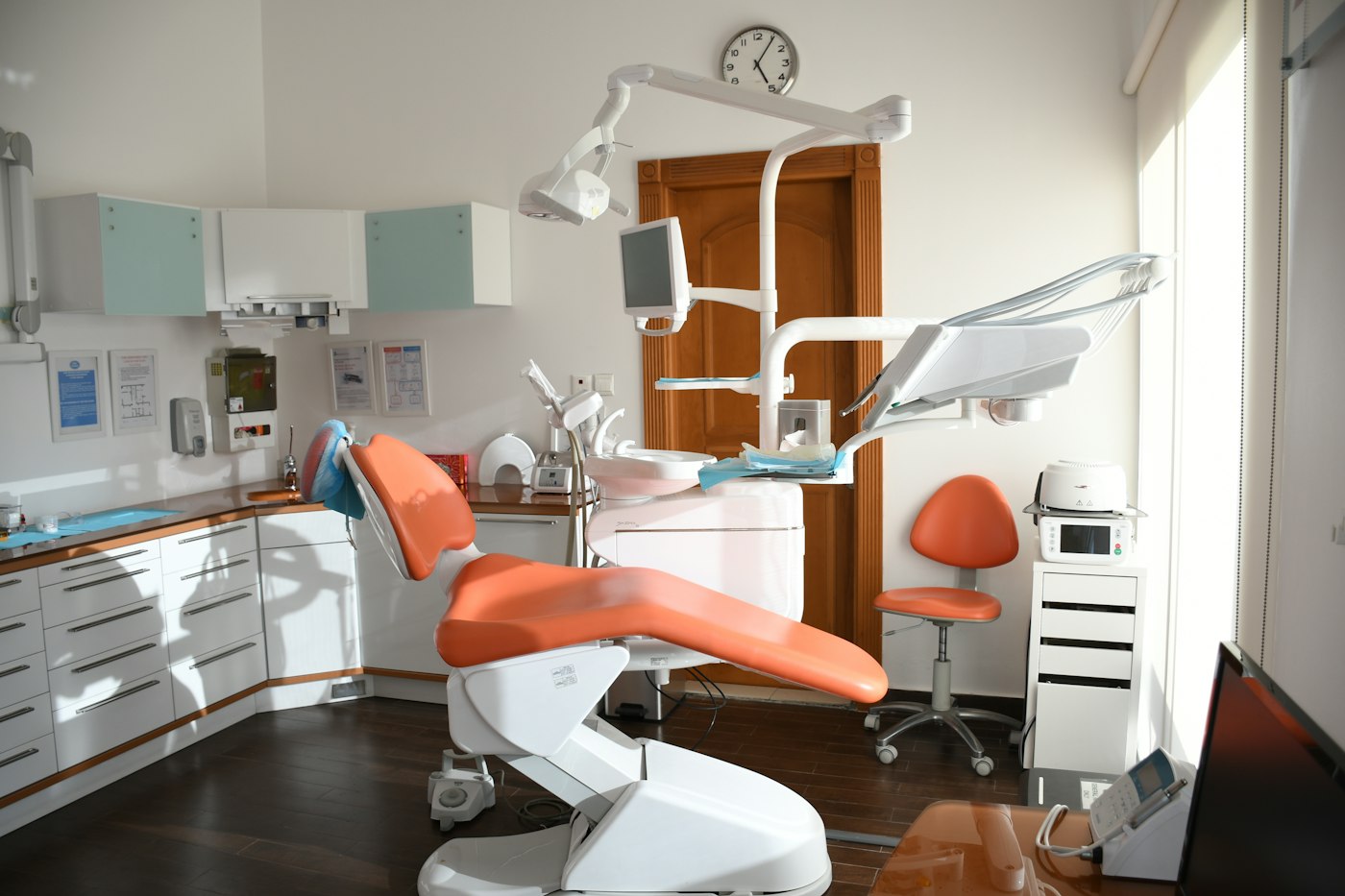 Orange dental chair in a bright clinical office